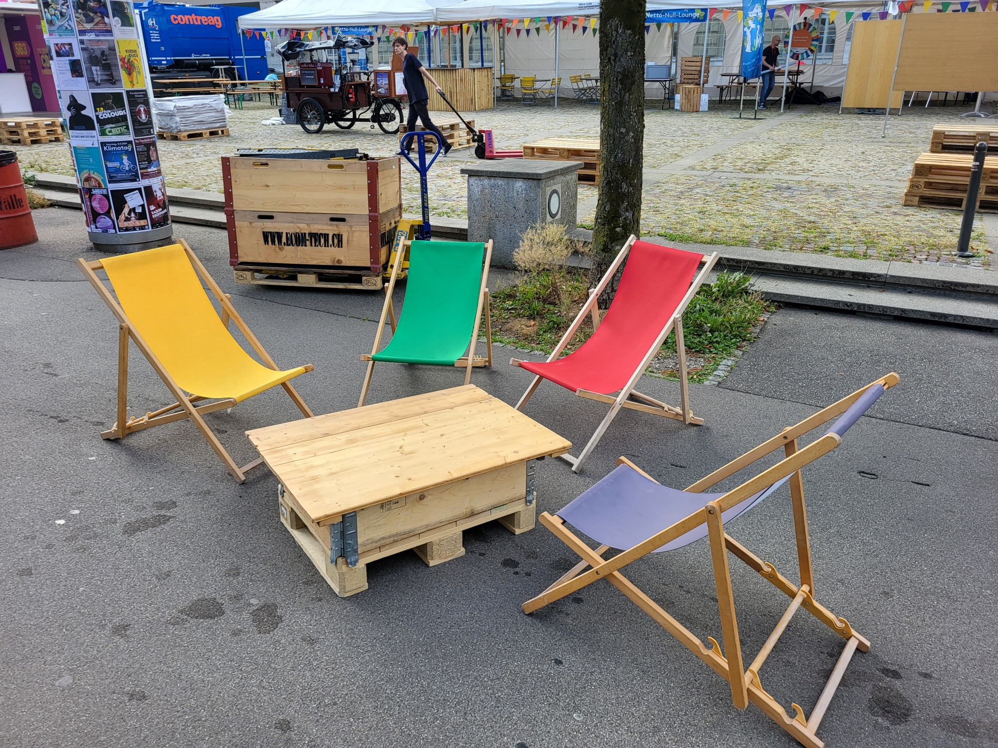 Bunte Liegestühle um einen Tisch. Clubtisch mieten
