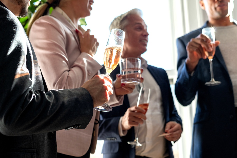Feiernde Menschen mit Getränken. Sektgläser mieten: Stilvolle Eventausstattung für jeden Anlass